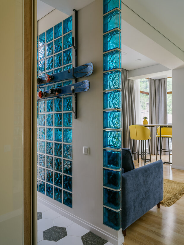 На стене из стеклоблоков разместили крепление для лыж и сноубордов.