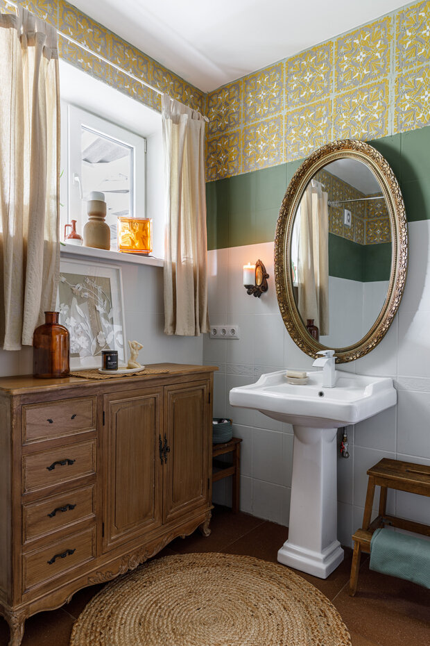 Интерьер ванной комнаты в винтажном стиле с антикварным комодом и овальным зеркалом