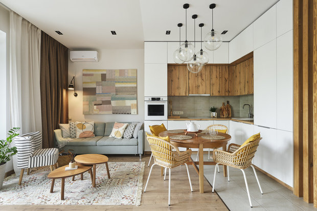 Кухонный гарнитур выполнен на заказ. Вся техника встроенная, стандартная. Верхние шкафы сделали разными по глубине, чтобы увеличить вместимость кухни — хозяйка очень любит готовить. Сбоку у гарнитура выдвижная секция до самого потолка — для бакалеи, масел. 