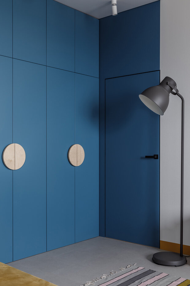 Системы хранения реализованы в виде скрытых шкафов до потолка, расположенных в прихожей и переходящих в кухню-гостиную. Это позволило разместить все необходимые вещи и технику, которые есть у заказчиков.