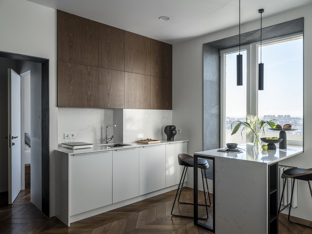 В результате перепланировки кухню и спальню поменяли местами. Сама кухня осталась в мокрой зоне, но ее повернули в сторону комнаты. Кухонный фартук, столешница на кухне и острове сделана из керамогранита Vicostone.