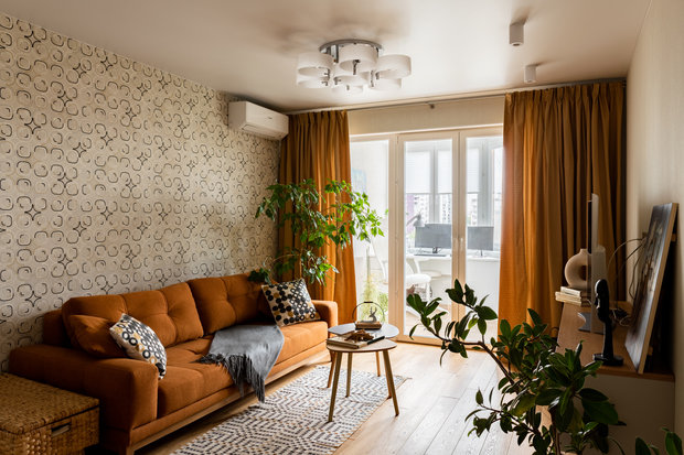 За счет рыжей обивки дивана и штор в тон кажется, что в комнате всегда солнечно.
