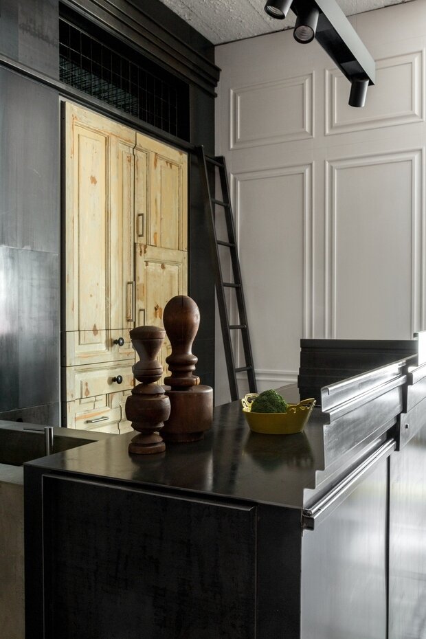 Кухня изготовлена из листов черной стали под матовым лаком. Этот материал привлек своими естественными разводами и стойкостью к повреждениям.