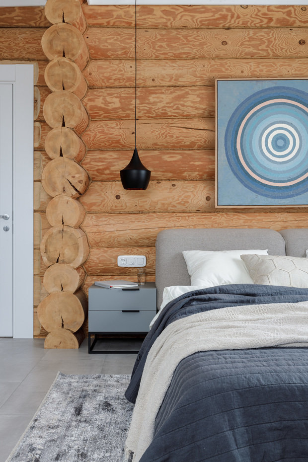 Для декора в изголовье кровати подобрали картину, имитирующую срез дерева. 