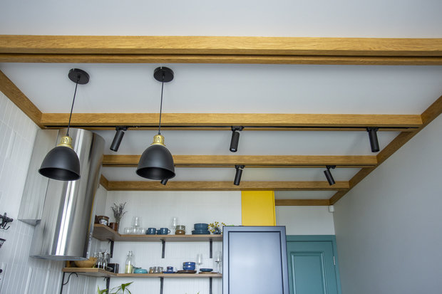 На потолке сделали деревянные балки, в которые встроили шины для светильников.