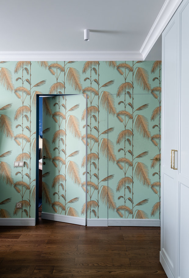 Двери в спальню и в детскую сделали скрытыми. На них поклеили обои и разместили плинтус: это получилось сделать за счет того, что двери открываются внутрь комнат и снабжены обратно-поворотными петлями.