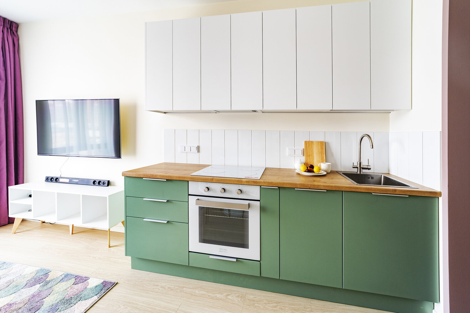 За счет того, что холодильник спрятан в нише за раздвижной дверцей напротив кухни, удалось сохранить визуальную легкость всей композиции и выделить больше места для зоны гостиной.