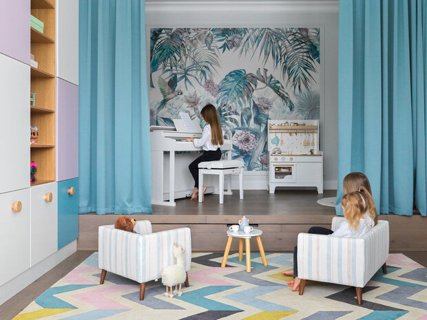 Красивые обои-панно с распускающимися бутонами цветов, с пальмовыми листьями и райскими птицами расположили в детской игровой зоне.