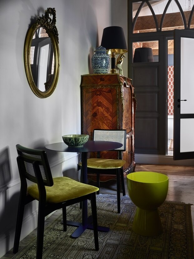 Напротив кухонного гарнитура контрастом расположился вычурный старинный комод-бар в стиле Людовика XV, в котором хозяева спрятали кофемашину.