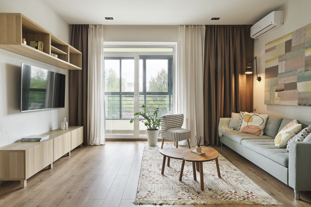 Вся мебель подбиралась на основе скандинавского стиля с элементами кантри. Так, в гостиной появилось маленькое кресло с полосатым принтом на ткани — под зебру. Столики в цвете орех, напоминающие Африку, и голубой диван, ассоциирующийся с небом. В зоне кухни деревянный круглый стол и стулья напоминают о дачных посиделках.  