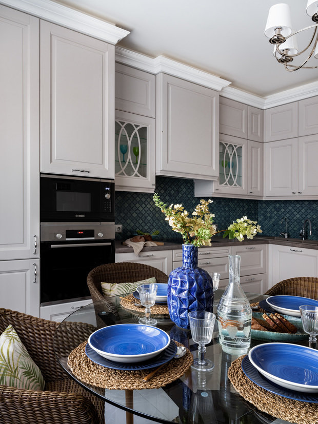 Столешница должна была быть очень неприхотливой, износостойкой, не впитывать влагу и грязь, поэтому выбор пал на пластик. При этом выглядит он стильно. Фартук выложили мелкой мозаикой изумрудного цвета.