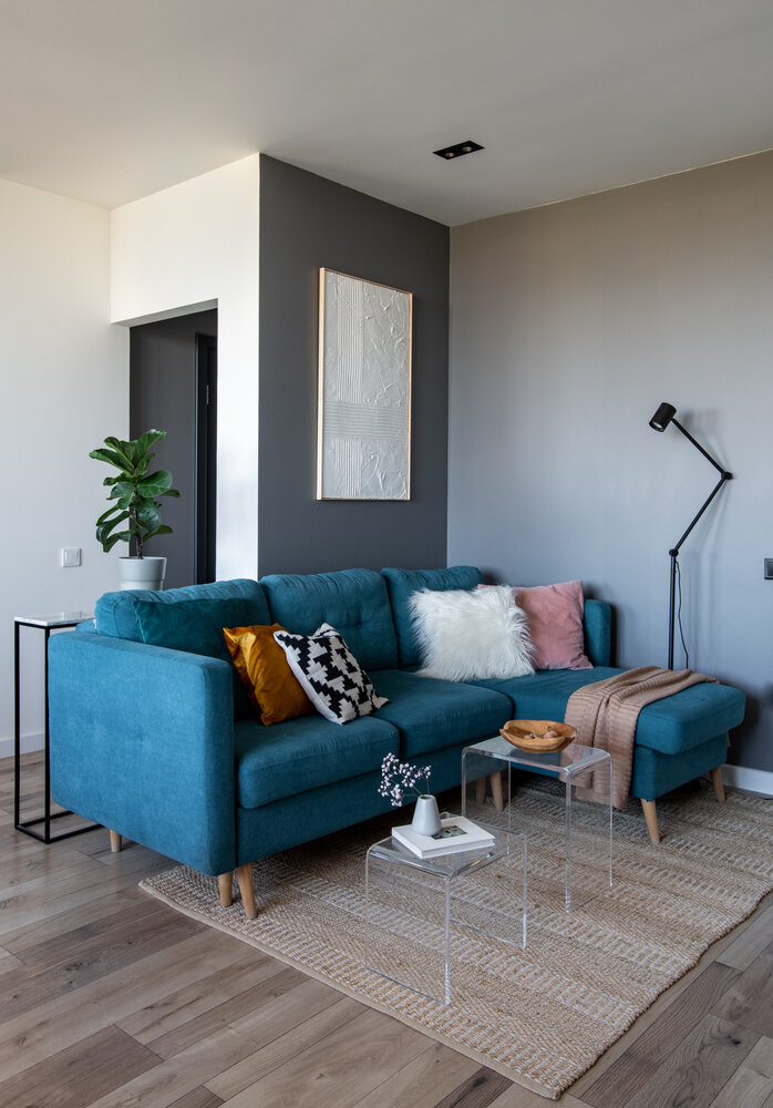 В диванной зоне расположилось декоративное гипсовое панно, которое подчеркивает архитектурные линии планировки, добавляет фактуры на гладкой серой стене и делает это зону более сложной.