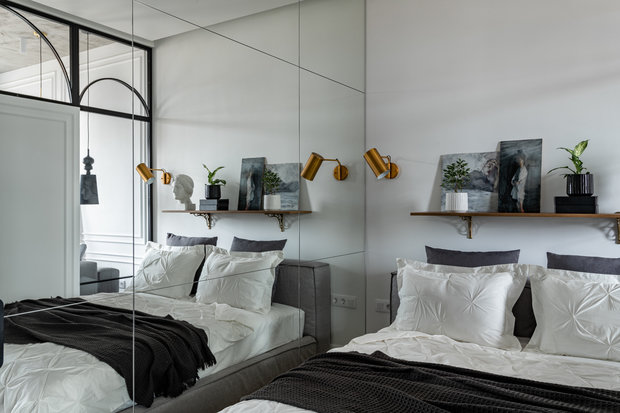 Для расширения пространства одну из стен спальни оформили зеркальными полотнами.