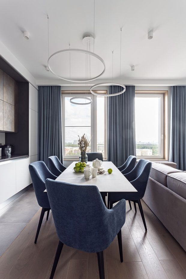 Над обеденным столом повесили стильные круглые светильники.