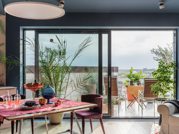 Одним из важных решений была установка прозрачной перегородки во всю стену между гостиной и террасой, это позволило визуально продлить пространство гостиной и впустить озеленение террасы в интерьер.