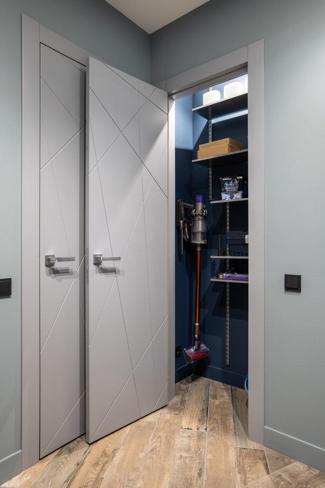 Для хранения бытовых средств, утюга, пылесоса, инструментов, химии выделили небольшую нишу также в коридоре, чтобы эти вещи не находились в одном помещении с одеждой.