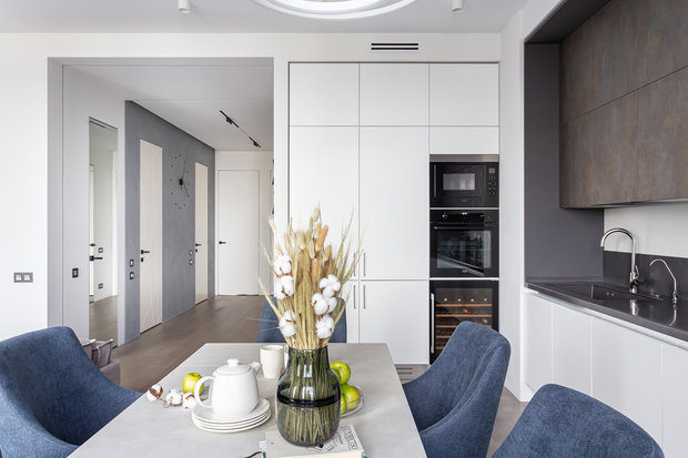 Нижние фасады и колонны спроектировали в белом цвете, чтобы они не сильно выделялись. Другую часть фасадов выделили с помощью текстуры травертина. Столешница из искусственного камня.