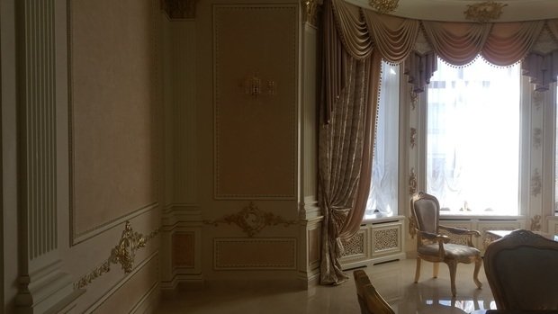 Интерьер гостиной в классическом стиле с лепниной и креслами