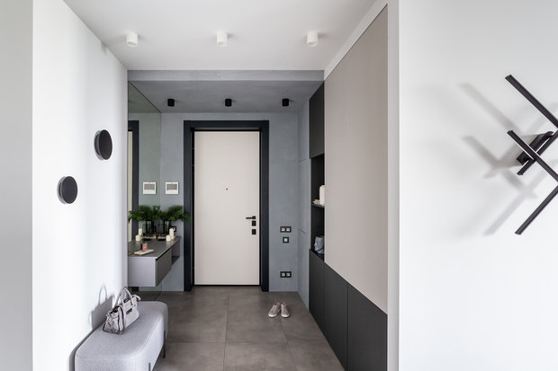 Стены в прихожей оформили микроцементом серого цвета. А дверь оставили белой, чтобы ее выделить.