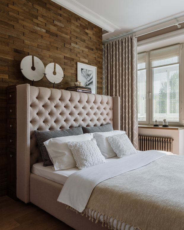 За изголовьем кровати поставили высокий комод с боковыми ящиками, он заменил традиционные прикроватные тумбы.