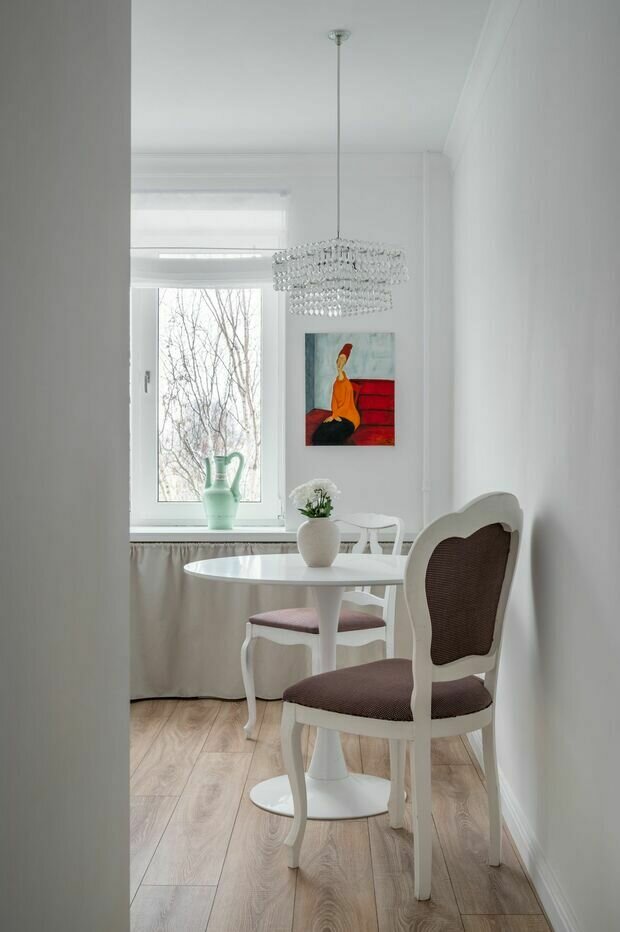 Стол и стулья купили на сайте подержанных вещей, их покрасили и сменили обивку. Над столом — винтажная люстра.