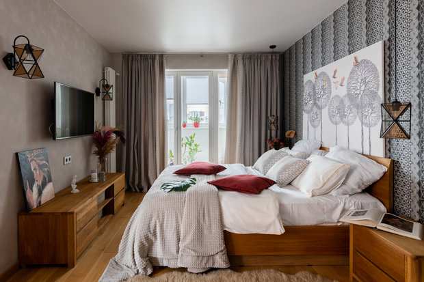Акцентом в зоне спальни выбрали контрастные обои с геометрическим рисунком, в поддержку им подобрали ткани на шторы с такой же геометрией. Пестрые элементы уравновесили однотонными стенами.