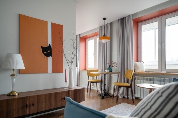 Кухонный стол с чугунным подстольем и столешница из массива — фишка интерьера. Деревянные подоконники из массива, цветные откосы хорошо передали настроение этой квартиры, на них можно отдыхать с прекрасным видом на Москва-Сити.