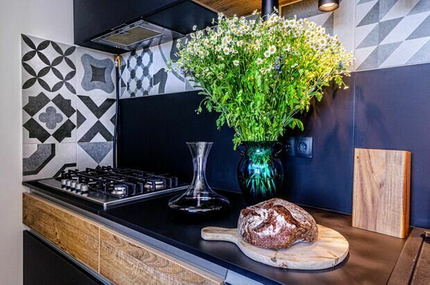 Нижний уровень кухонного фартука сделан из того же материала, что и сама кухня, а верхний — из керамогранита с орнаментом.