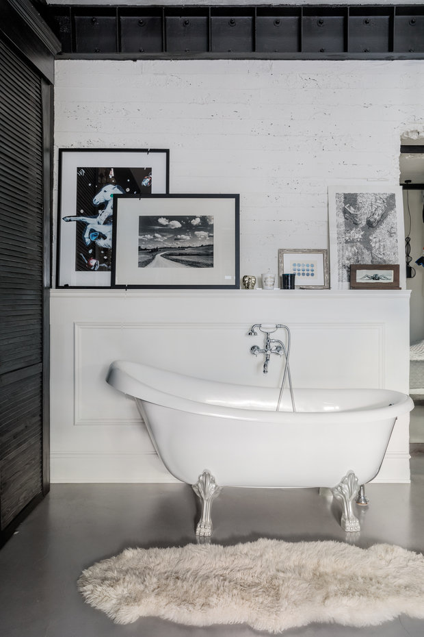 Интерьер ванной в стиле лофт с отдельно стоящей белой ванной