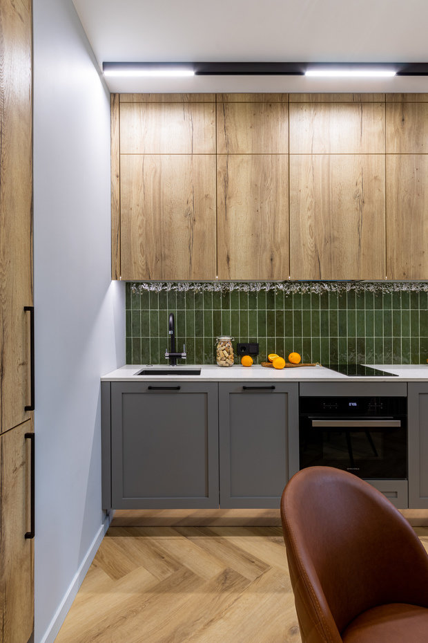 Кухонный гарнитур изготовлен по индивидуальному проекту, холодильник встраиваемый в нише, варочная панель на две конфорки, духовой шкаф с функцией СВЧ и встраиваемая посудомоечная машина.