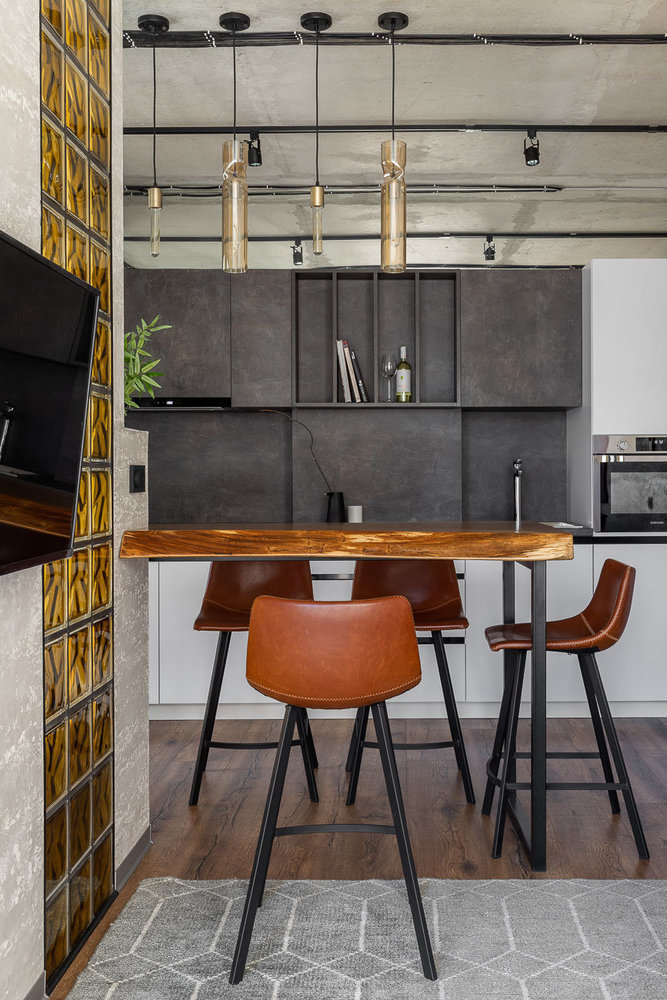 Кухонные шкафчики сделаны не до потолка, а сверху над ними добавлено зеркало, которое визуально расширяет пространство, добавляет воздуха и создает ощущение, что помещение этой стеной не ограничено. Вообще в этом интерьере много зеркал, они позволяют визуально изменить пространство и добавить света в интерьер.