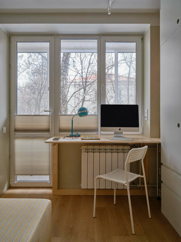 Рабочий стол интегрирован в подоконник. Он раскладной: часть столешницы опускается в случае, если понадобится больше пространства.