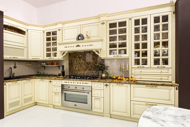 Интерьер кухни в классическом стиле с белыми шкафами и столешницей из мрамора