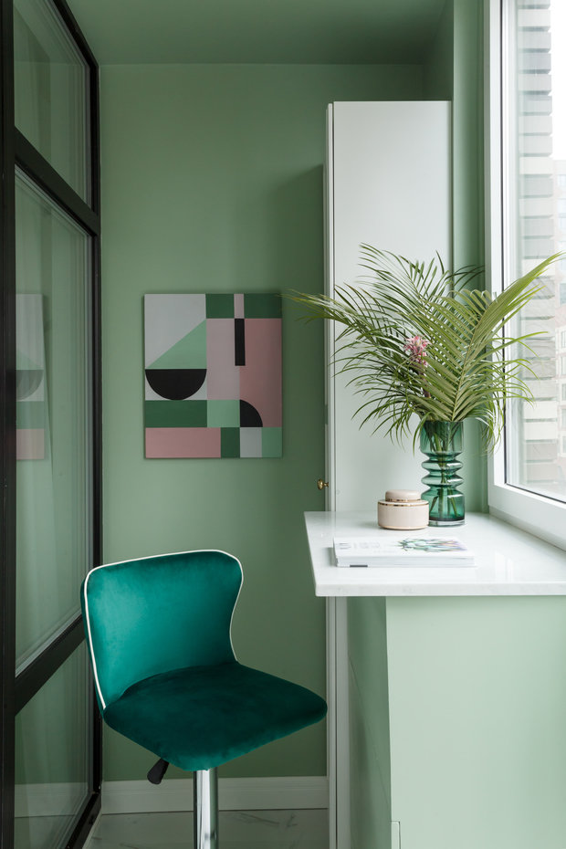 Интерьер кабинета в современном стиле с изумрудными стенами и геометрической картиной