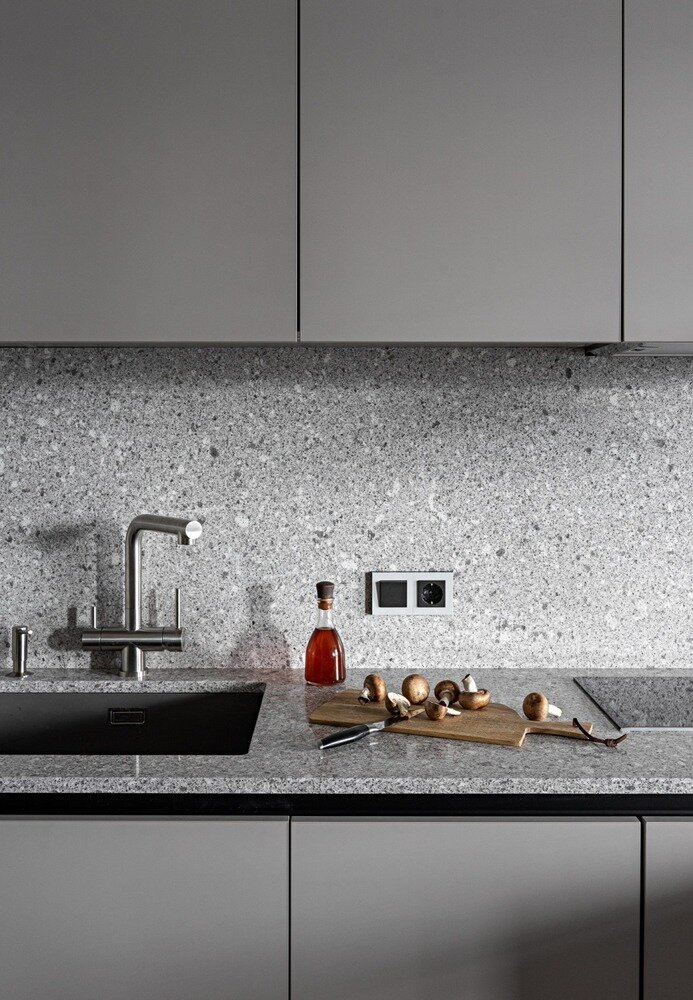 Кухонные фасады изготовлены из материала Fenix. Он очень прочный и стойкий, на его поверхности не остаются отпечатки пальцев. Кухонная столешница и фартук выполнены из кварцевого агломерата. Кварц не боится ножей и горячего, что делает его идеальным для кухни. Кухонные фасады изготовлены из материала Fenix. Он очень прочный и стойкий, на его поверхности не остаются отпечатки пальцев. Кухонная столешница и фартук выполнены из кварцевого агломерата. Кварц не боится ножей и горячего, что делает его идеальным для кухни.