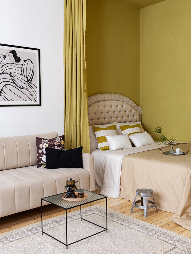 Монохромная диванная зона отлично разбавляет и уравновешивает яркие луговые цвета. Тут расположились двухметровый раскладной диван, журнальный столик и ковер, который своими приглушенными орнаментами соединяет все зоны.