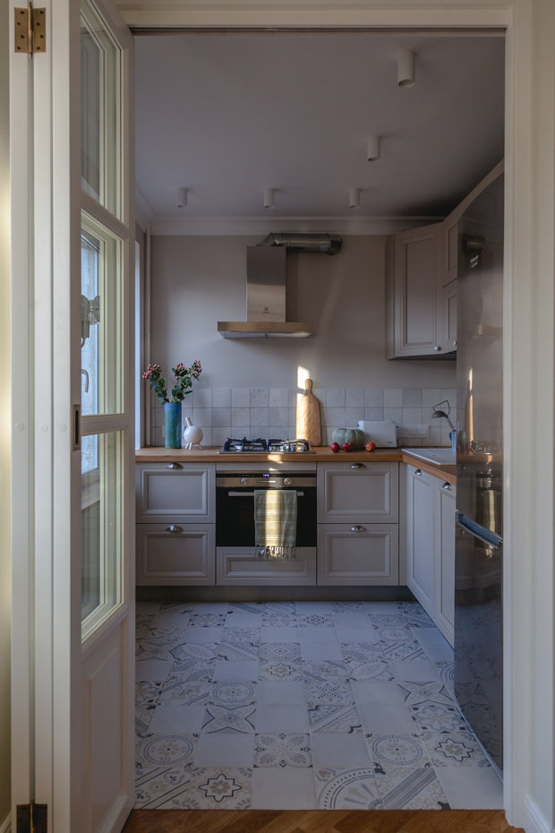 Вся кухня сделана на заказ, она хоть и небольшая, но полноценная, духовой шкаф совмещен с микроволновой печью, а компактный размер позволяет сделать дополнительный ящик. Есть посудомоечная машина. Так как заказчица готовит нечасто, крупной бытовой техники нет, но все необходимое поместилось, верхнее хранение организовано по одной стороне, что облегчает пространство.