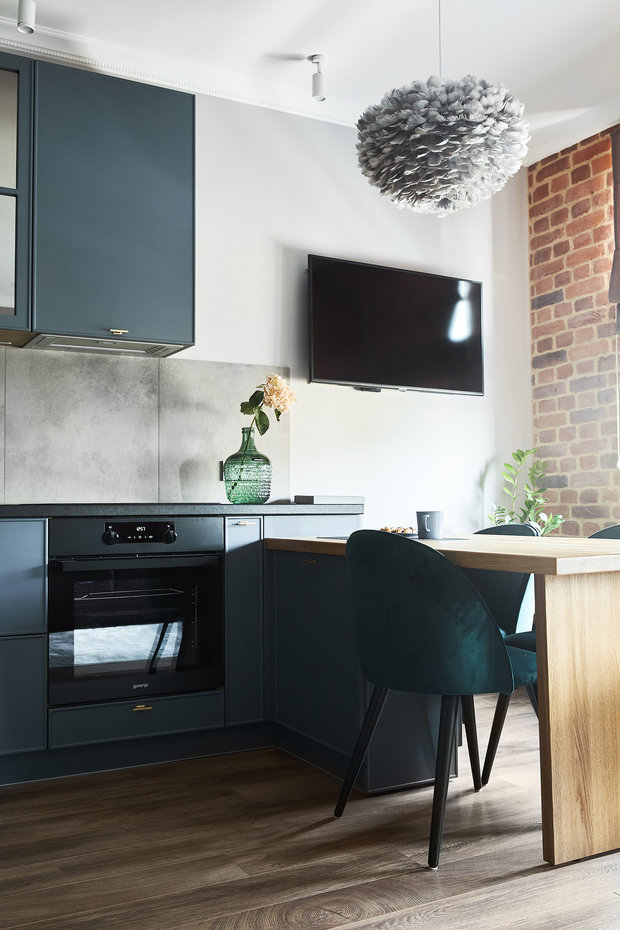 Гарнитур переходит в обеденный стол из массива дуба, где также есть системы хранения. За столом могут разместиться до пяти человек, а еще это удобное место для работы.