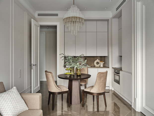 Обеденную зону подчеркнули темным столом и шикарной люстрой, которая не сможет остаться незамеченной.