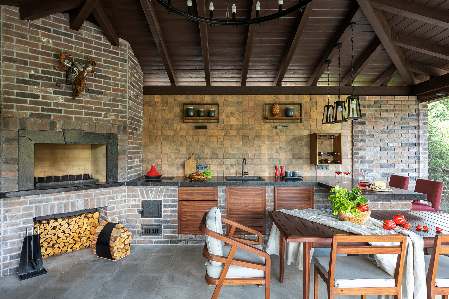 Стены облицованы декоративным кирпичом, на полу натуральный камень, потолок — дерево.