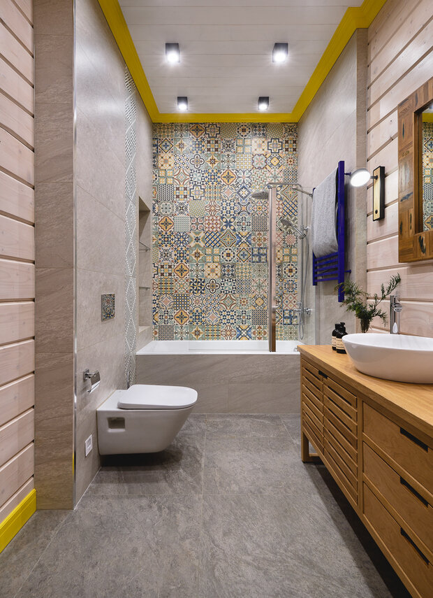 Детский санузел, хотя и достаточно яркий, но подходит для разновозрастных детей, взрослому человеку в нем тоже комфортно находиться. Акцент создали с помощью цветных карнизов и яркой плитки.