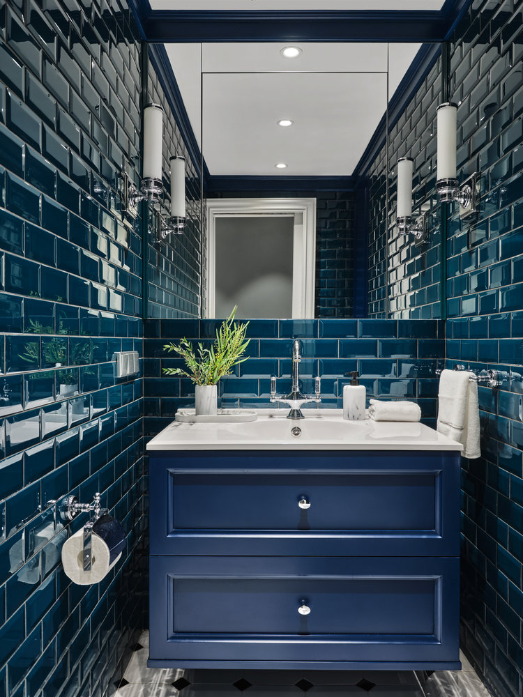 Самый нарядный — гостевой санузел, где за зеркалом спрятали щиток, а в потайном шкафу организовали бытовое хранение.