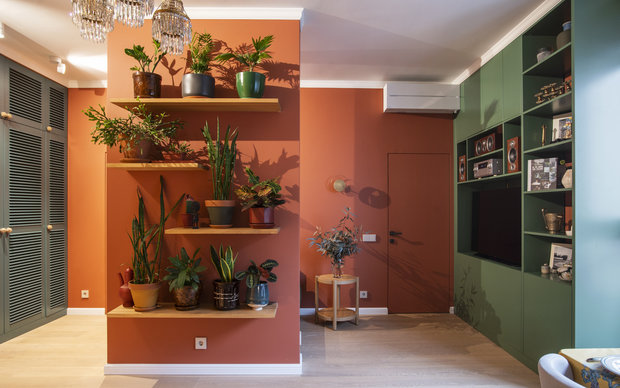 Несущий пилон в центре общей зоны нарастили, чтобы скрыть за ним торец дивана. Лицевую часть перегородки украсили полками с растениями. 