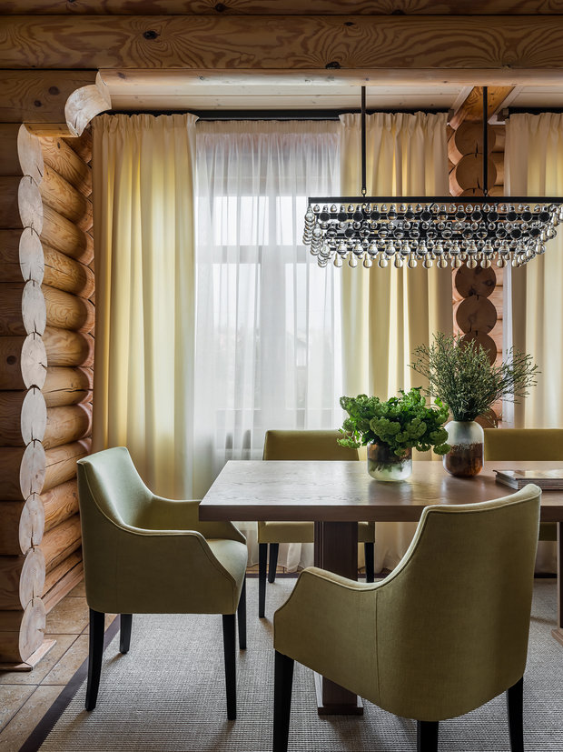 В обеденной зоне разместили большой деревянный стол, окруженный мягкими стульями с высокой спинкой.