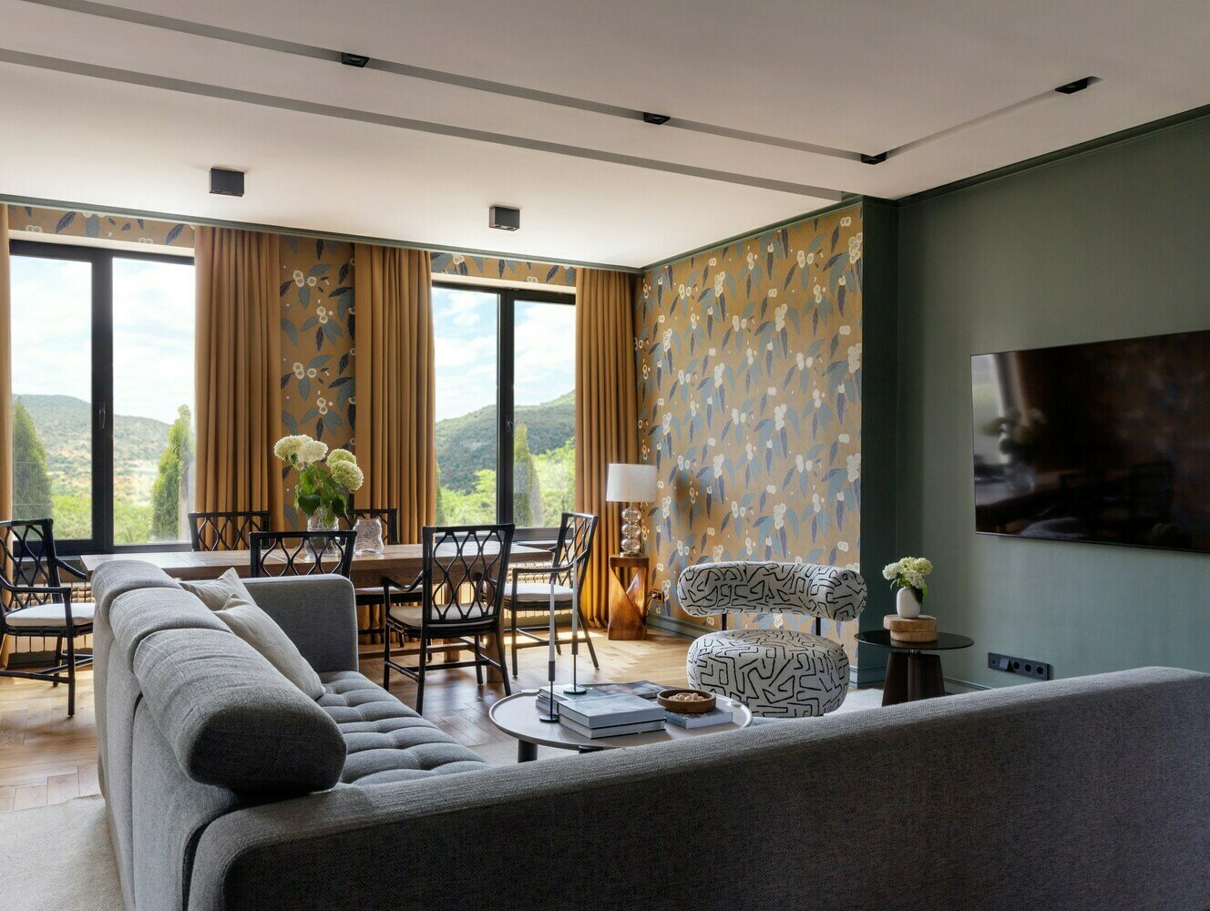 Основное покрытие стен — краска, в некоторых зонах использованы обои брендов Harlequin и KT Exclusive. Они помогают создать акценты, не нарушая целостности пространства. Например, в зоне столовой, где есть ниша у окна, скрывающая трубы, стены украшены обоями, что добавляет уюта и завершенности интерьеру. Основное покрытие стен — краска, в некоторых зонах использованы обои брендов Harlequin и KT Exclusive. Они помогают создать акценты, не нарушая целостности пространства. Например, в зоне столовой, где есть ниша у окна, скрывающая трубы, стены украшены обоями, что добавляет уюта и завершенности интерьеру.