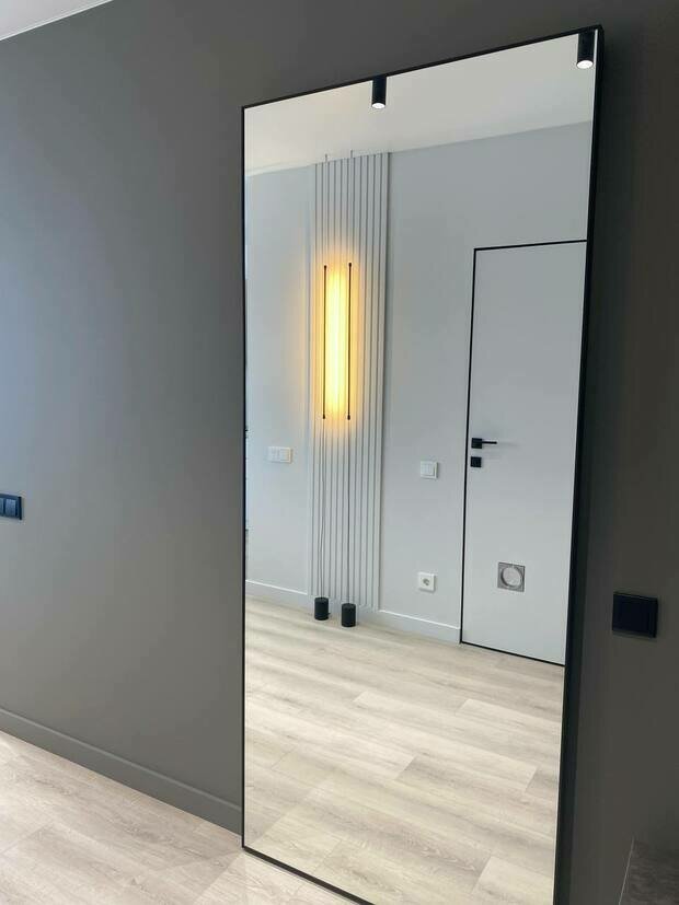 Интерьер прихожей в стиле минимализм с большим зеркалом и вертикальным светильником