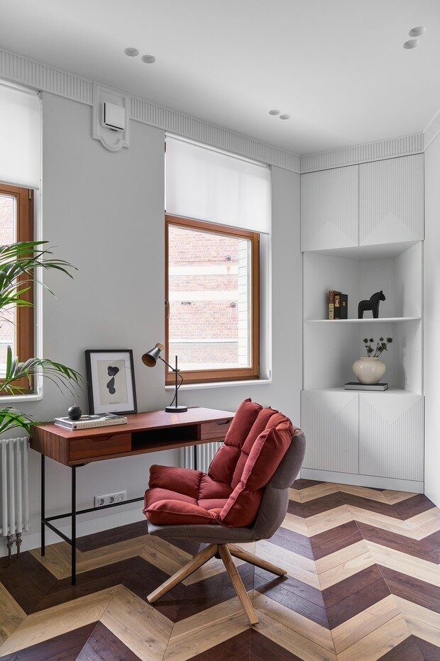 В кабинете внимание привлекает двухцветная раскладка паркета зигзагом.