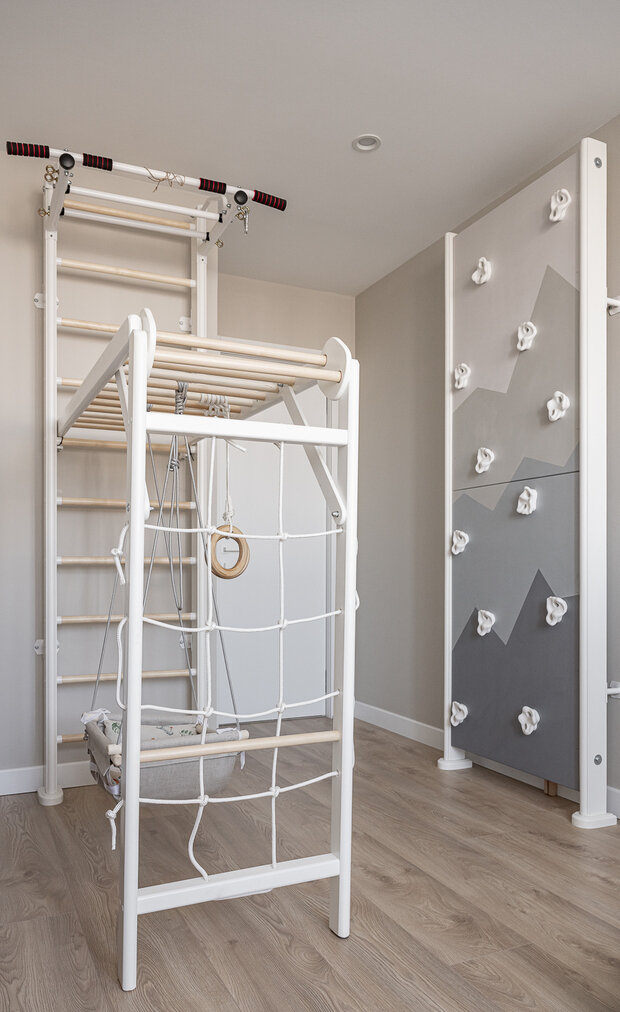 В комнате сына тоже расположили игровой комплекс. Скалодром декорировал художник — нанес рисунок стилизованных горных вершин.