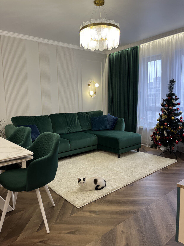 Интерьер гостиной в современном стиле с изумрудным диваном и креслами