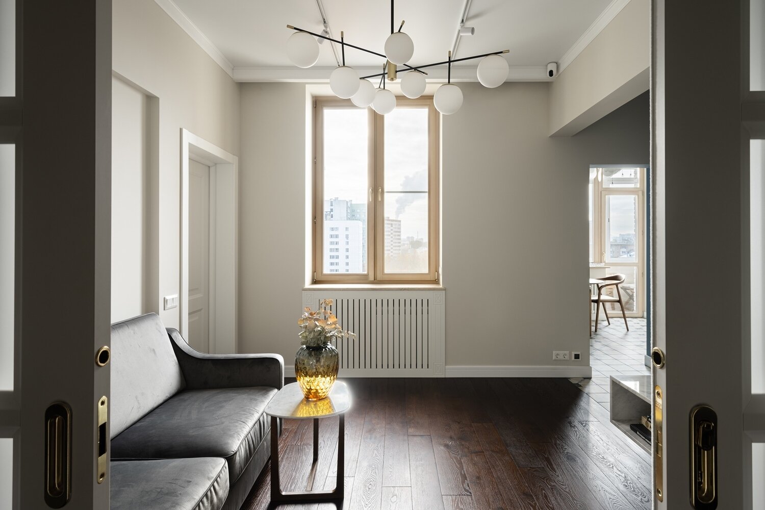 Радиаторы отопления спрятали за экранами, которые заказчики приобрели до начала ремонта. На пол положили доску темного цвета.